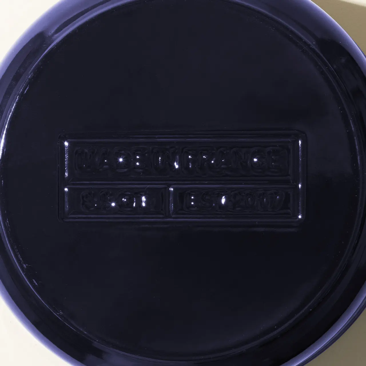 A close-up of a glossy black plate with embossed lettering that reads "MADE IN FRANCE" and "LE 2001."