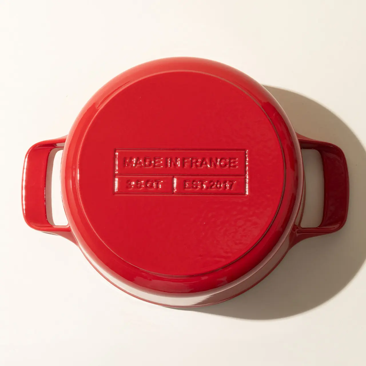 A red enameled cast iron pot with the text "MADE IN FRANCE" embossed on the lid, indicating its country of manufacture.